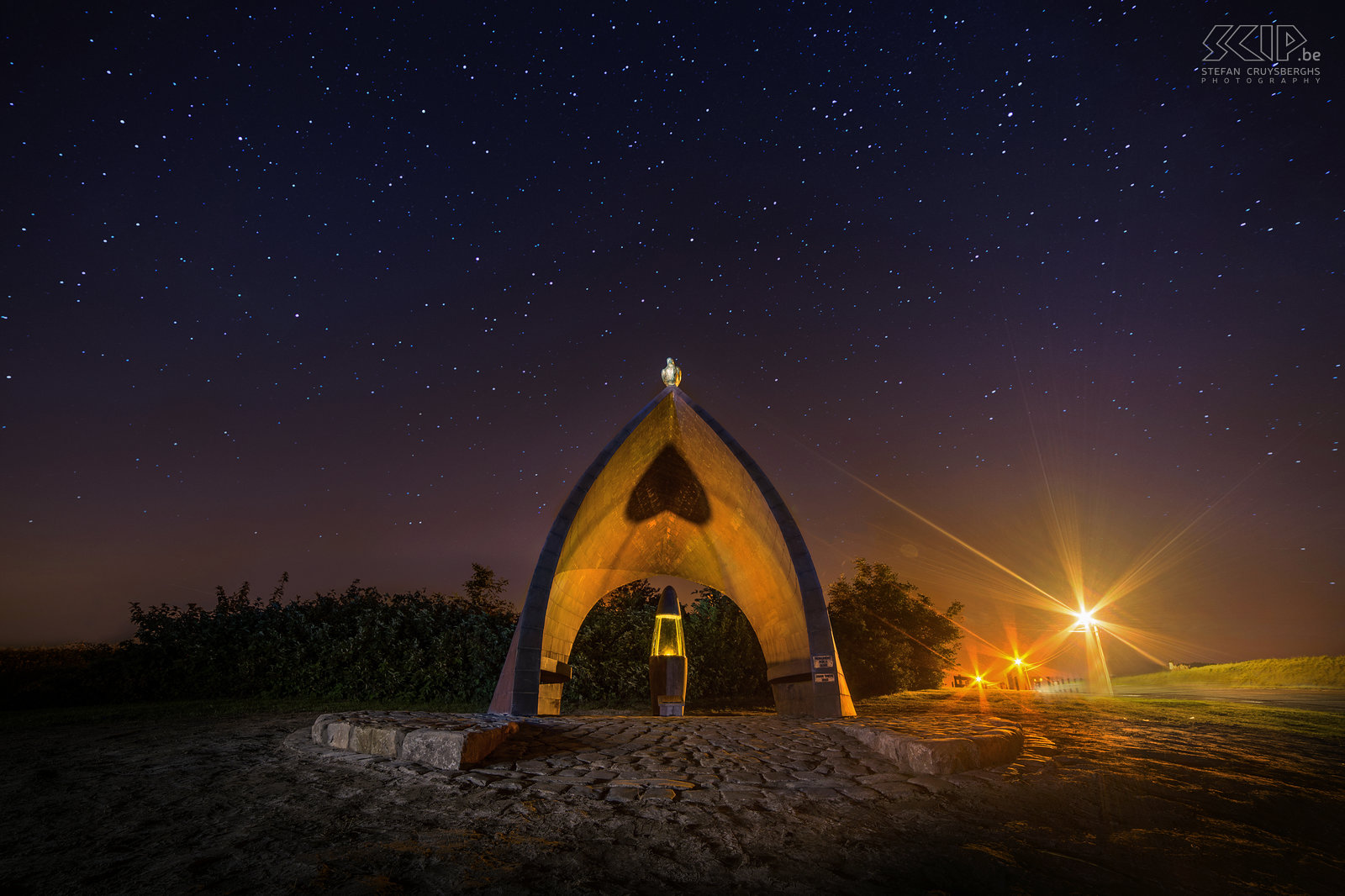 Hageland by night - Wereldvredesvlam in Holsbeek De Wereldvredesvlam van de kunstenaar Daan Theys in Holsbeek op een plek waar de drie deelgemeentes samenkomen. Het monument is het symbool van het verlangen van ieder mens om vrede in zijn leven te vinden.  Stefan Cruysberghs